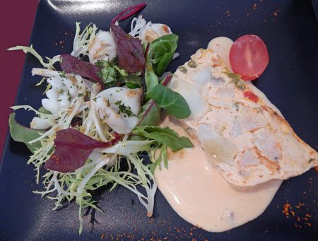 photo of monkfish terrine on sauce with salad of lettuce and calamari