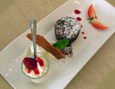 Dessert trio including chocolate molten cake, ice cream, whipped cream