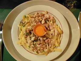 photo of tagliatelle carbonara with its egg to mix